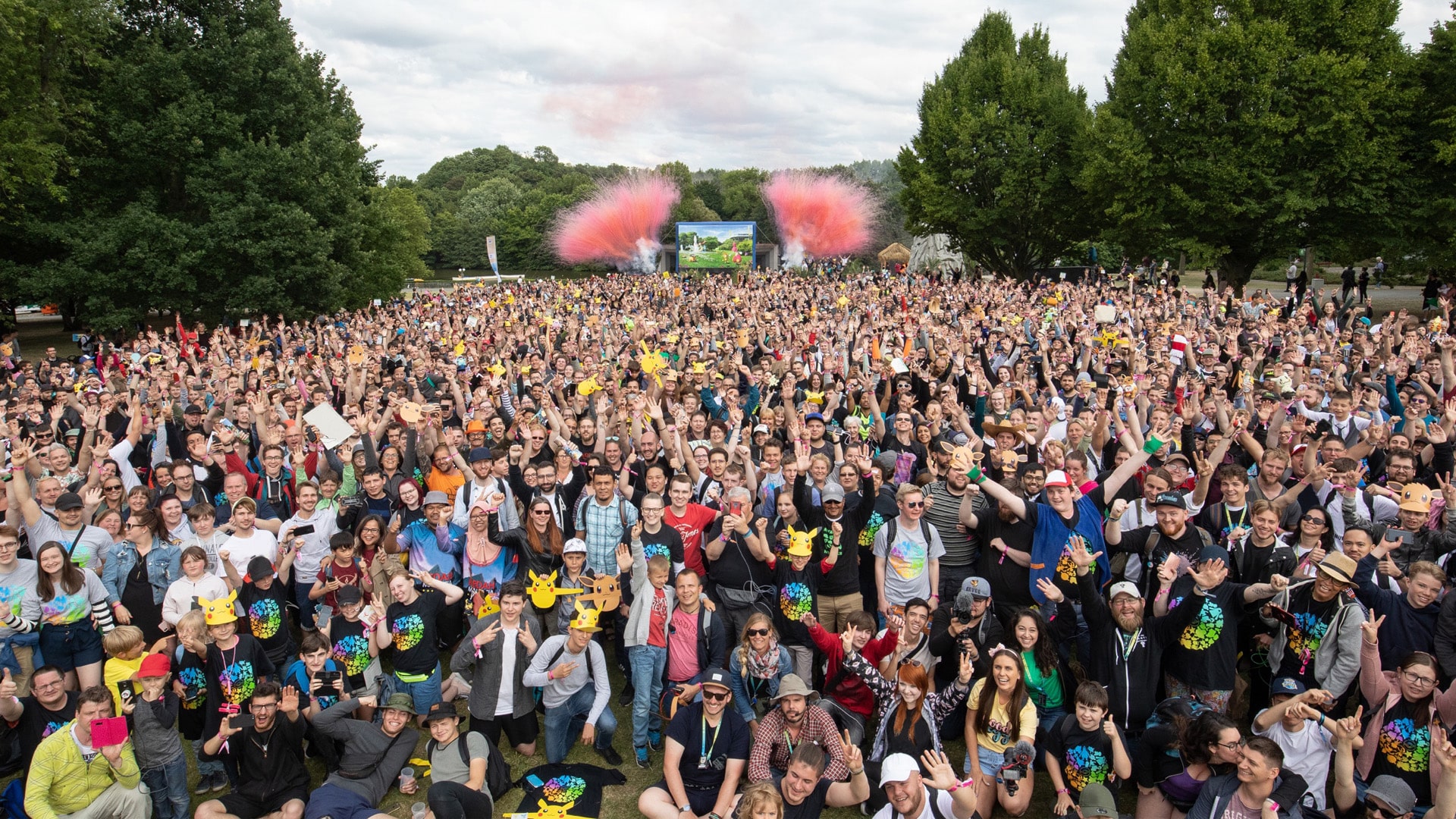 Crowd of people playing Pokemon GO in a public park