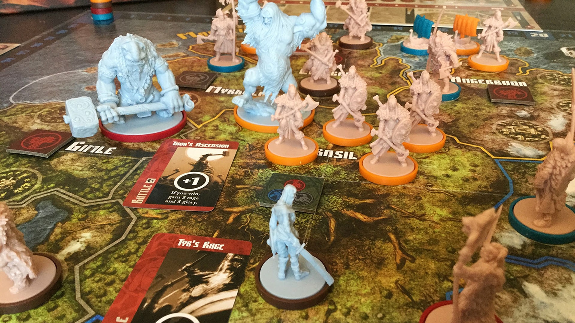 A dynamic setup of the Blood Rage board game, featuring Viking-themed miniatures, cards, and a vividly illustrated game board.