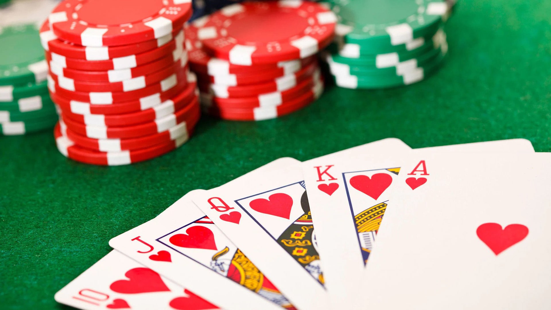 Poker: The Timeless Classic of Strategy and Skill in Tabletop Gaming A close-up view of a poker game in action, showcasing playing cards and chips on a classic green table.